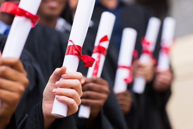 personas sosteniendo su diploma de graduado