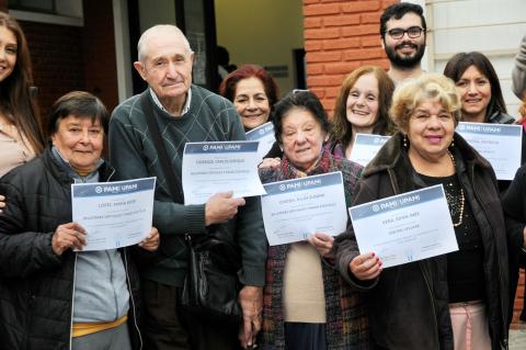 Adultos mayores con sus certificados en la UTN
